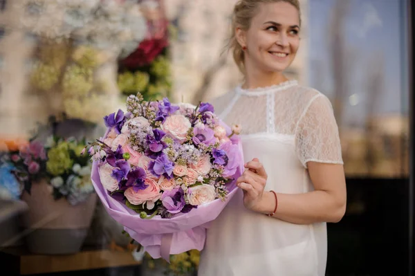 Chica se levanta al aire libre con asombroso ramo de flores — Foto de Stock