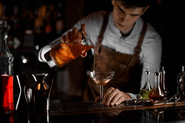 Barkeeper gießt Alkoholcocktail aus einem Sieb — Stockfoto