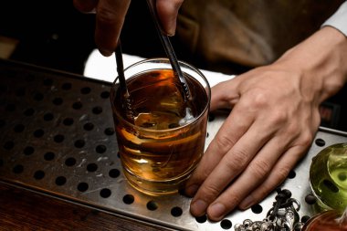 Barmen viski bir buz küpü ekleyerek
