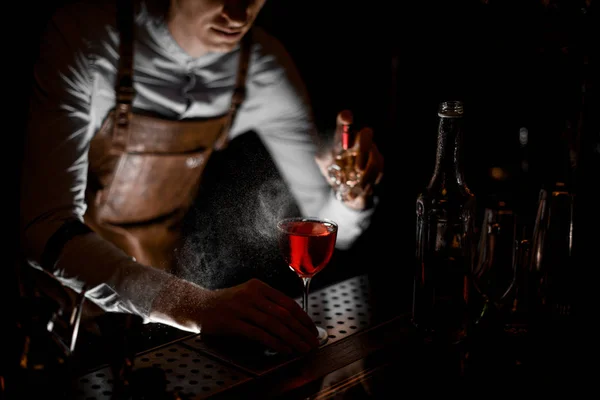 Bartender pours an alcohol cocktail with sprayer — Stock Photo, Image