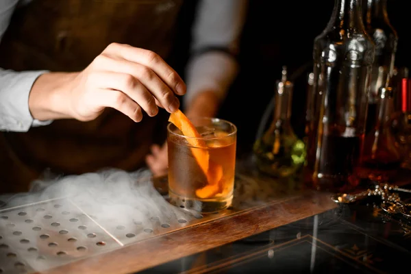 Cantinero pone ralladura naranja en vaso de whisky — Foto de Stock