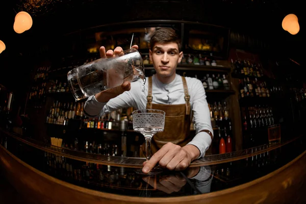 Barman jovem derrama coquetel de um jarro — Fotografia de Stock