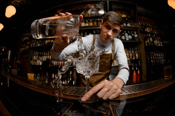 Jovem barman derramando coquetel do frasco — Fotografia de Stock