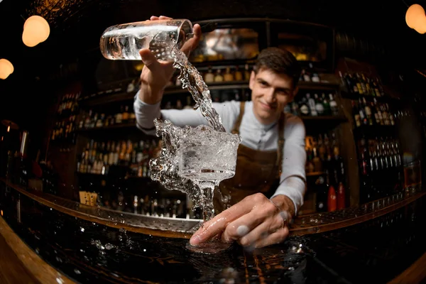 Young bartender pours drink from the jar — Stock Photo, Image