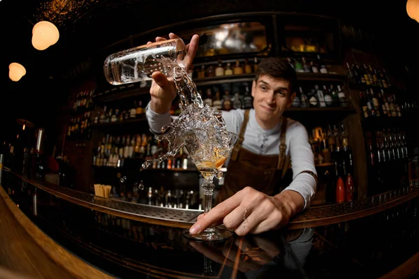 Ung bartender häller alkohol från en burk — Stockfoto