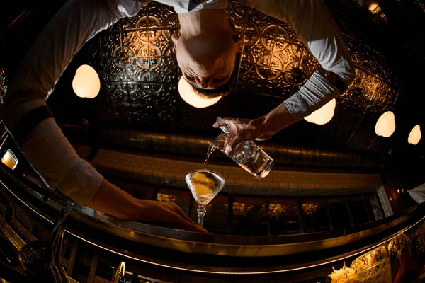 Junger Barkeeper schüttet Alkohol aus dem Glas — Stockfoto