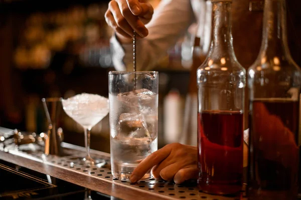 Barman agitando bebida alcoólica com colher especial — Fotografia de Stock