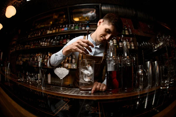 Barman mexe bebida alcoólica com colher especial — Fotografia de Stock