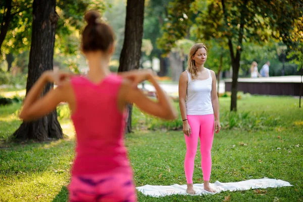 Women practice yoga in the park in the calming pose — Stock Photo, Image