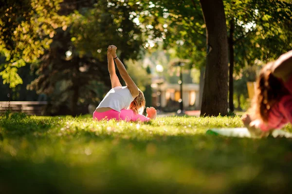 Frau im Sportanzug übt Yoga im Park — Stockfoto