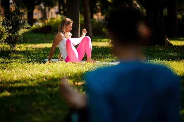 Women in sportsuits practice different yoga poses in the park — Stock Photo, Image