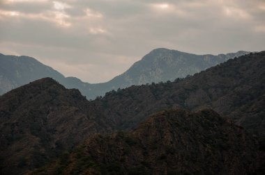 Işık ile bulutlu gökyüzü altında dağ peyzaj