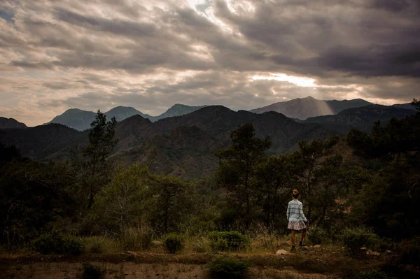 Дівчина стоїть на прекрасному пейзажі гори під хмарним небом — стокове фото