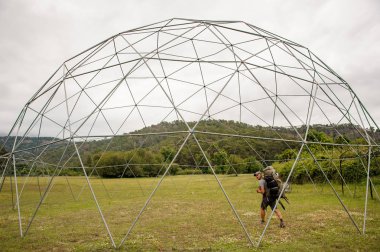 Adam alanın ortasında küresel inşaat boyunca yürüyüş