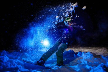 Dağ yamacında sürme yeşil bir spor giyim giymiş aktif kadın snowboardcu