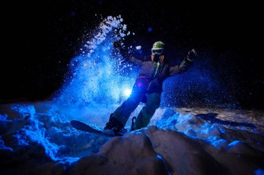 Karda binen yeşil bir spor giyimli kadın snowboardcu