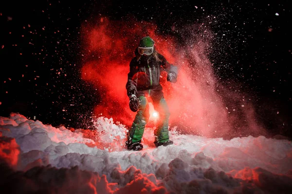 Активна жінка сноубордистка, одягнена в зелений спортивний одяг, що стоїть на схилі снігу — стокове фото