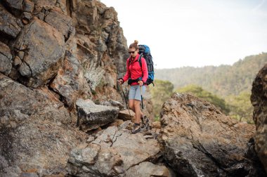 Dağlarda sırt çantası ile güneş gözlüğü seyahat kız