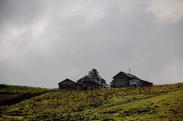 Paisagem das três casas de madeira na colina — Fotografia de Stock