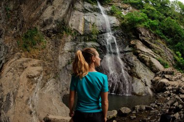 Balık gözü fotoğraf arka görüş kız ayakta ve ormanda güzel şelale bakıyor
