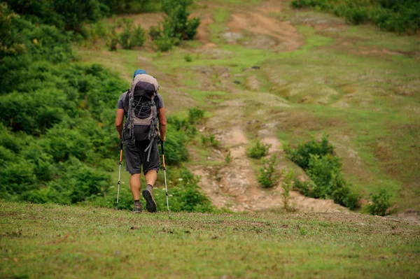 Mužská turistka s batohu v údolí — Stock fotografie