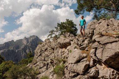 Kız baston ile güzel manzara üzerinde kaya üzerinde duran