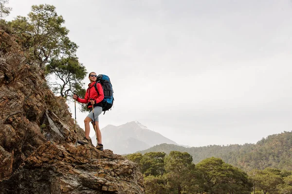 Donna sportiva in piedi sulla roccia con zaino da trekking — Foto Stock