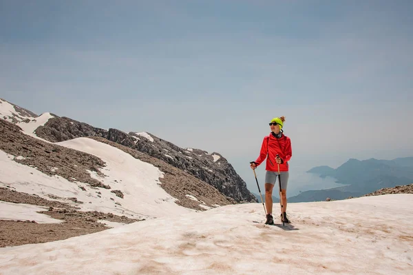 Turista femenina con bastones en las montañas — Foto de Stock