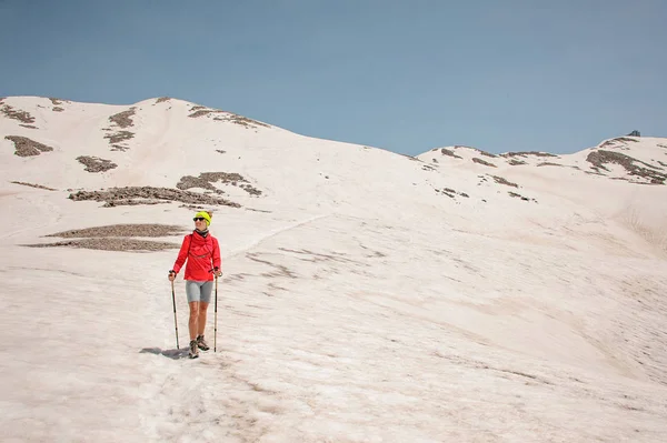 山の中で歩く棒を持つ女性ハイカー — ストック写真