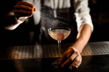 Limon suyu ekleyerek cam bir kokteyl hizmet veren profesyonel barmen