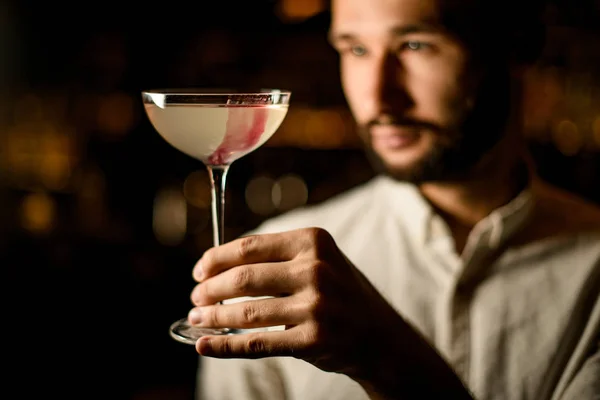 Barista professionista che presenta un cocktail nel bicchiere decorato con cubetto di ghiaccio rosa — Foto Stock