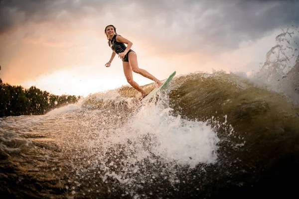 Deportiva chica cabalgando en el wakeboard en el río —  Fotos de Stock