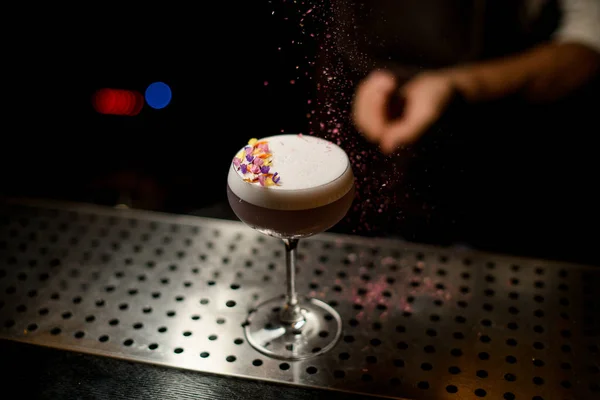 Barman polvilhando no coquetel com escumalha branca decorada com pétalas de flores um desfiado flores — Fotografia de Stock