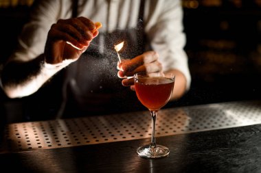 Çekici barmen bir limon suyu ile yanan maç üzerine püskürtme cam bir kokteyl hizmet