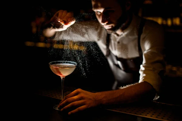Atractivo camarero que sirve un cóctel en el vaso rociándolo con un jugo de limón — Foto de Stock