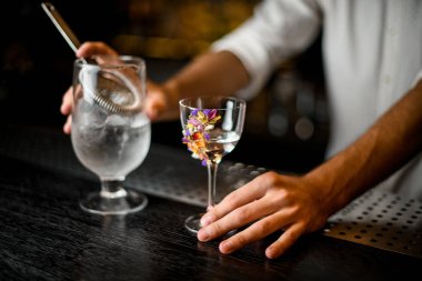 Barmen bir süzgeç ile camdan alkol döker