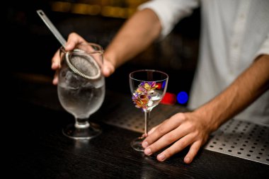 Barmen bir süzgeç ile camdan alkol dökme