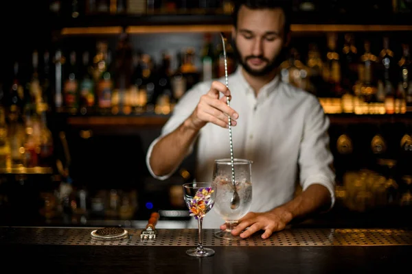 Cantinero revuelve un cóctel de alcohol con cuchara de bar — Foto de Stock