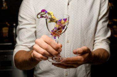 Barmenlerin elinde su sıçratan alkolün yakın çekimi.