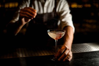 Barmen tezgahın cam bir alkol serpiştirir