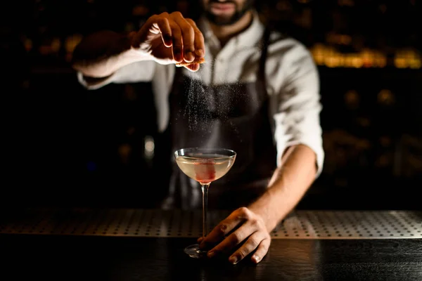 Cantinero rociando alcohol en vidrio sobre un mostrador — Foto de Stock