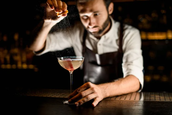 Barkeeper streut Cocktail in Glas auf einen Tresen — Stockfoto