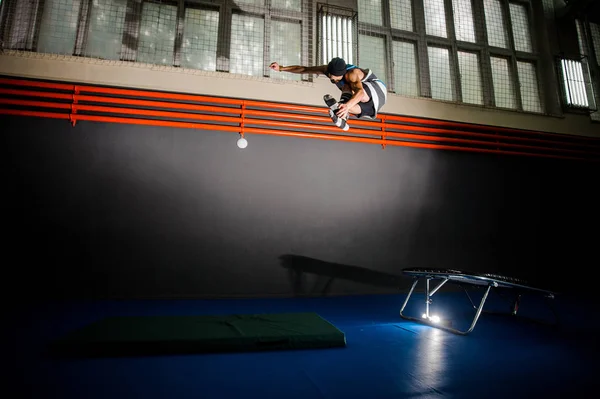 Jonge man springen op de trampoline in de sportschool — Stockfoto