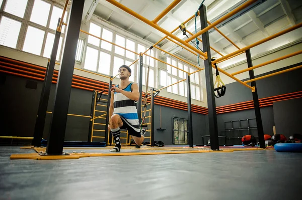 Jovem fazendo exercícios esportivos no ginásio — Fotografia de Stock