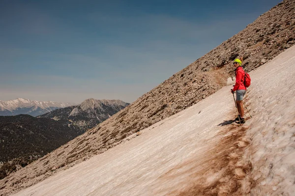 ハイキングスティックでタタリ山の汚れた雪道に立っている女の子 — ストック写真