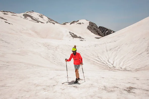 ハイキングスティックでタタリ山の汚れた雪の上を歩く少女 — ストック写真