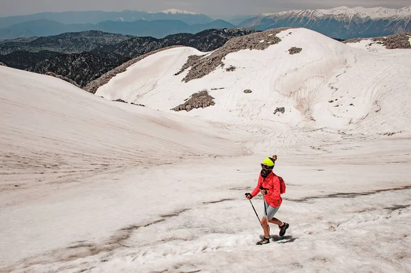Femme sportive marchant sur la neige sale sur la montagne Tahtali avec des bâtons de randonnée — Photo