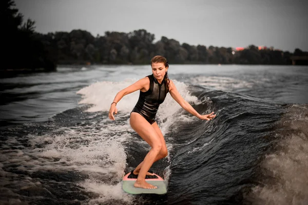 Pretty girl wakesurifing in the river near forest — ストック写真