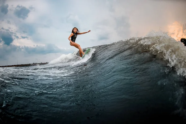 Young girl glides on a wakeboard in the river near forest — ストック写真