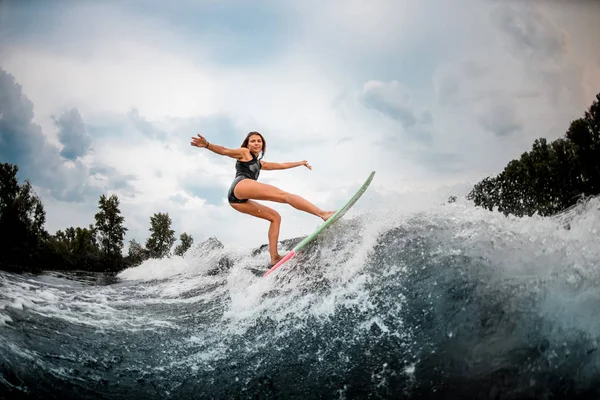 Mulher wakesurfer fazendo acrobacias em uma placa — Fotografia de Stock